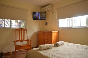 a bedroom with a bed and a dresser and a television at Departamentos temporarios La Nueva Costanera in Posadas