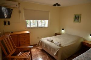 a bedroom with a bed and a chair and a window at Departamentos temporarios La Nueva Costanera in Posadas