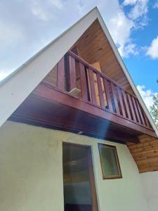 a house with a balcony on top of it at Chalés Alto da Serra 3 in Campos do Jordão