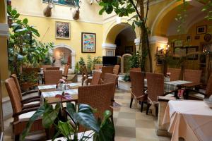 a restaurant with tables and chairs and plants at Hotel Ungarische Krone in Bruckneudorf