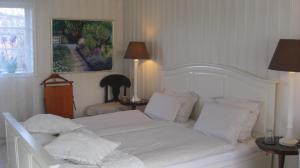 una camera da letto con un letto bianco con lenzuola e cuscini bianchi di Ängshyddan B&B a Yngsjö