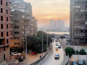 una vista di una strada cittadina con auto ed edifici di كورنيش المعادى بالقرب من مستشفى السلام الدولى a Il Cairo