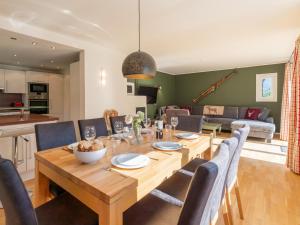 a dining room and living room with a wooden table and chairs at Villa Taube in Bad Gastein