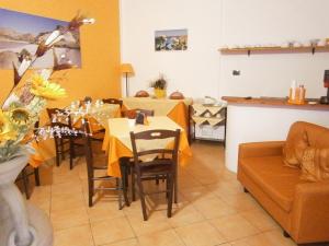 a dining room with a table and a couch at B&B La Rosa Lampedusa in Lampedusa