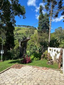 un jardín con una entrada de piedra y una colina en Casa com vista para as montanhas, en Sapucaí-Mirim