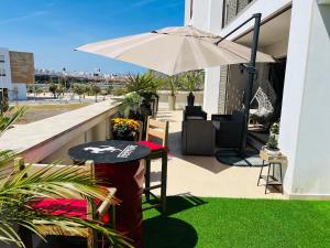 サレにあるMarina Salé Luxury Apartment, Sea Viewのパティオ(テーブル、傘付)