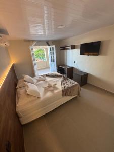 a bedroom with a large bed and a window at Hotel Pousada Villa Marina in Fortaleza