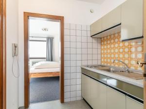 a kitchen with a sink and a room with a bed at Brixen Alpin Living Top 1 und 2 und 3 in Brixen im Thale