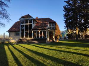 a house on a grassy field with a tree at House IZI - parking, garden, 8 min ride to center in Maribor