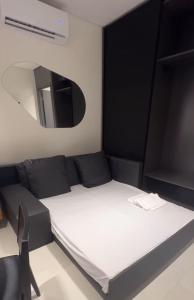 een kleine kamer met een bed en een spiegel bij Flat Beira Mar Gavresorts in Porto De Galinhas