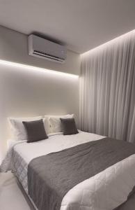 een slaapkamer met een bed en een tv aan de muur bij Flat Beira Mar Gavresorts in Porto De Galinhas