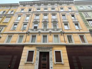 a yellow building with windows and a door at Piccola camera in appartamento condiviso con terrazza vista mare in Trieste