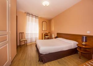 a hotel room with a bed and a table and chairs at Hotel le Dauphin in Ajaccio