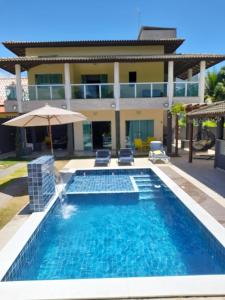 a swimming pool in front of a house at Casa amarela in Campos