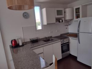 Una cocina con gabinetes blancos y un refrigerador blanco. en Movistar Arena, en Buenos Aires
