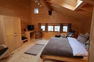 ein Schlafzimmer mit einem großen Bett in einer Holzhütte in der Unterkunft Chalet Diana in Le Sépey