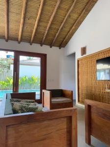 a living room with a table and a couch and a television at Casa Encanto de Minas em Trancoso in Trancoso