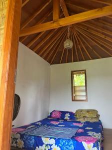 a bed in a room with a wooden ceiling at Herman Pondok Nyodok in Pawenang +11 photos