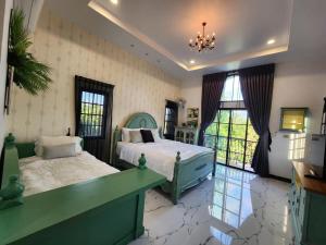 a large bedroom with two beds and a chandelier at T1-Tuscany Private Pool Villa-บางแสน in Ban Hua Khao Sammuk