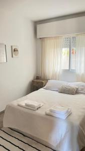 un lit blanc avec deux serviettes dessus dans l'établissement Casa Raíz, à Santa Rosa de Calamuchita