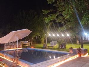 a swimming pool at night with an umbrella next to it at Urku Wasi II in Chilecito
