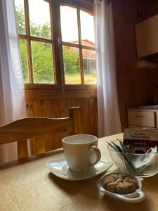 a table with a cup of coffee and a bowl of cookies at Cabañas Santa Flavia in Yacimientos de Río Turbio