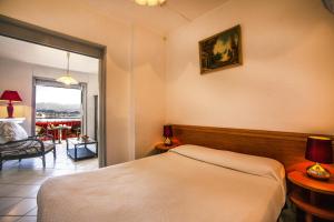 a hotel room with a bed and a balcony at Hotel le Dauphin in Ajaccio