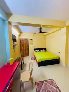 a bedroom with a green bed and a red desk at PG Homes in Port Blair