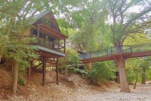 een boomhut met een brug in het bos bij TH 4 - Whippoorwill Haus in New Braunfels +12 foto's