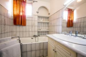a bathroom with a tub and a sink and a bath tub at Hotel le Dauphin in Ajaccio +37 photos