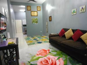 a living room with a couch and a flower rug at Seri Raban Homestay in Kampong Kuala Chegar