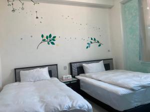 um quarto com duas camas e uma parede com borboletas em 福田民宿 台東民宿476號 em Guanshan