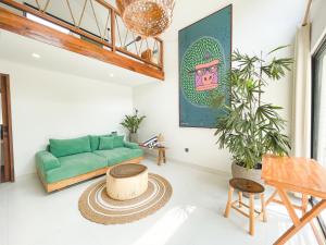 een woonkamer met een groene bank en een tafel bij CARI Surf Camp & Studio's in Uluwatu