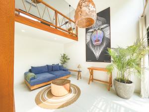een woonkamer met een blauwe bank en een tafel bij CARI Surf Camp & Studio's in Uluwatu