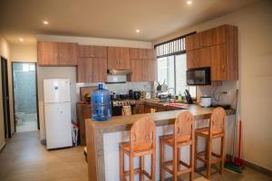 a kitchen with a counter with chairs and a refrigerator at La Vidita 891 - Piscinas, Lobitos in Lobitos +55 photos