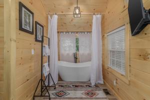 a bathroom with a bath tub in a wooden room at Firefly Haven - Summer Oasis with HOT TUB in Gatlinburg +68 photos