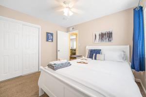 a bedroom with a white bed with a blue curtain at Longer Stays for Travelers- Apt Blocks from Hospital, Downtown in Visalia