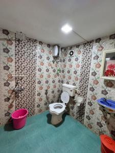 a bathroom with a toilet and a pink bucket at PG Homes in Port Blair +14 photos