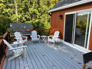 a deck with three chairs and a table on it at Fireplace Fire Pit Ski 5 Mountains 4BR Views in Thornton +20 photos