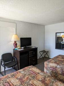 a hotel room with two beds and a flat screen tv at Paradise Falls Motel & Liquor LLC in Red Lake Falls