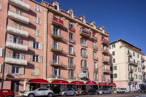 a large building with cars parked in front of it at Hotel le Dauphin in Ajaccio