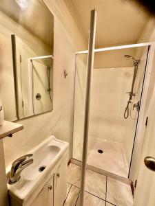 a white bathroom with a shower and a sink at Airport Guesthouse in Queenstown
