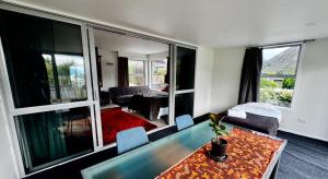 a living room with a table and some chairs at Airport Guesthouse in Queenstown +10 photos