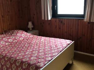 a bedroom with a bed with a red comforter and a window at Appartement central à Super Besse, 2 chambres, proche pistes - FR-1-814-11 in Besse-et-Saint-Anastaise