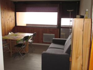 ein Wohnzimmer mit Sofa und Tisch in der Unterkunft Studio chaleureux au centre de Super Besse avec balcon - FR-1-814-9 in Besse-et-Saint-Anastaise