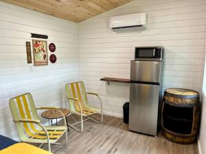 a room with a refrigerator and two chairs and a table at Patton's Run - Glamper in Bryson City