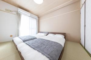 two beds in a room with a window at SUNNY House in Kashiwa