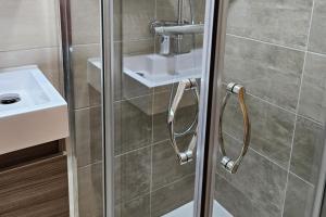 a shower with a glass door next to a sink at Cosy London Apartment with Great Views in London