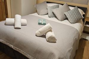 a white bed with pillows and towels on it at Cosy London Apartment with Great Views in London