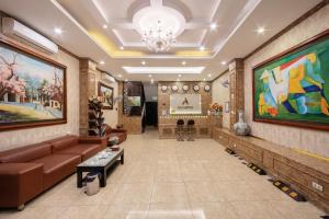 a lobby with a couch and paintings on the walls at A25 Hotel - 15 Hàng Than in Hanoi